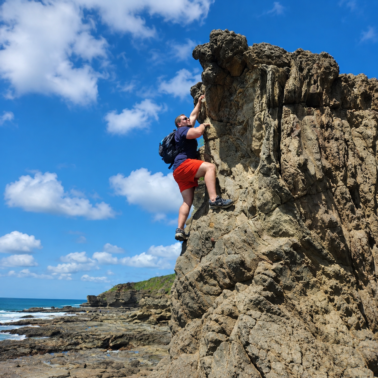 Ryan rock climbing a coastal cliff